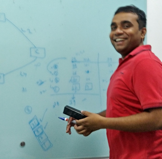 Praveen brainstorms on a whiteboard at Cisco India.