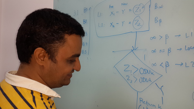 Navdeep writing on a whiteboard at the Cisco India office.