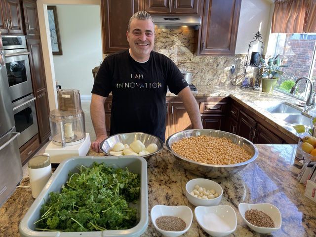 Nasser Tarazi in his kitchen with falafel ingredients laid out on the counter.