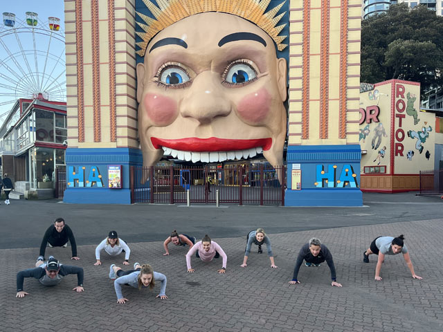 A group of people posing for a photo in front of a large building