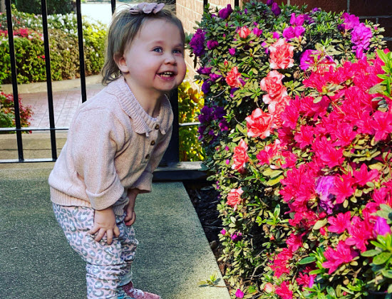 Kira is 19 months old and thriving. She loves smelling flowers.