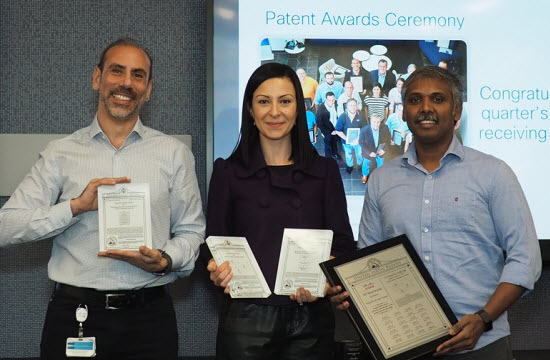 From left to right: Carlos Pignataro, Ruba Borno, and Nagendra at a patent award ceremony. Nagendra is holding his 25th patent.