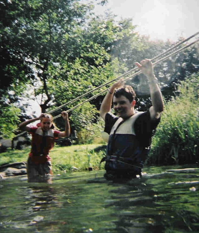 Nathan and another person standing in waist-deep water in the U.K.
