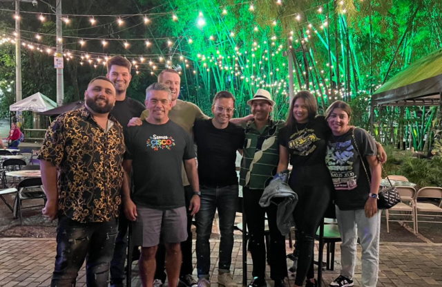 A group of people from the DNA Spaces sales team posing for a  photo in front of a lush green background.