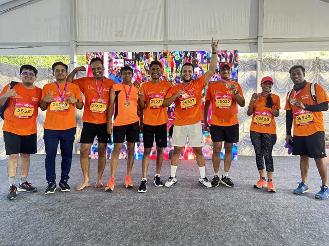 A group of nine runners show off their medals.
