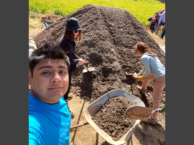 Jair and other volunteers digging dirt.