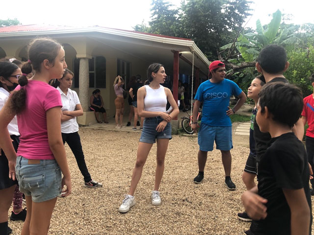 Two volunteers speaking to children.