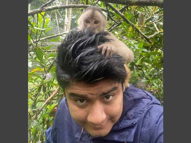 Jair with a small monkey climbing on his head.