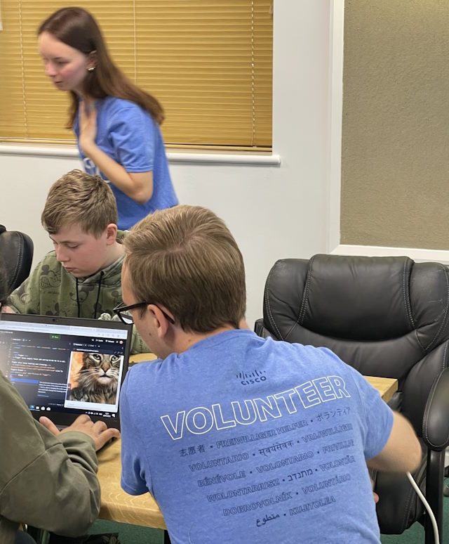 Volunteers James and Emily help the students work  through coding examples.