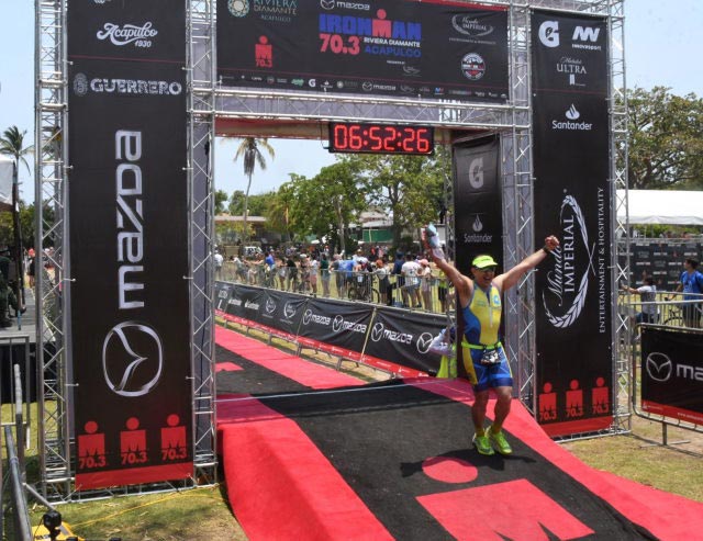 Victor posing at the finish line at the Half Ironman in Acapulco.