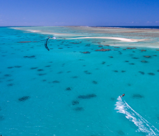 Cullen kiteboards around coral heads inside one of the largest atolls in the world