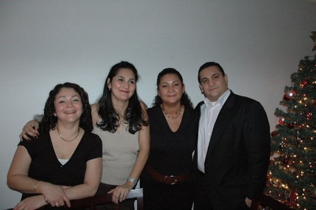 Vidal and his three sisters stand next to a Christmas tree.