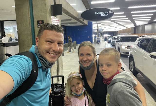 Alan, Lyla, Kelly, and Matthew in an airport parking area.