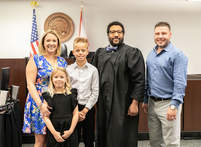 The whole family posed with a judge in the courtroom.