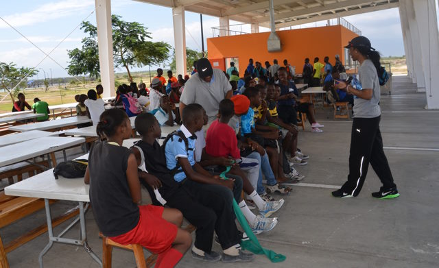 Pascale speaking to a group of children outside.