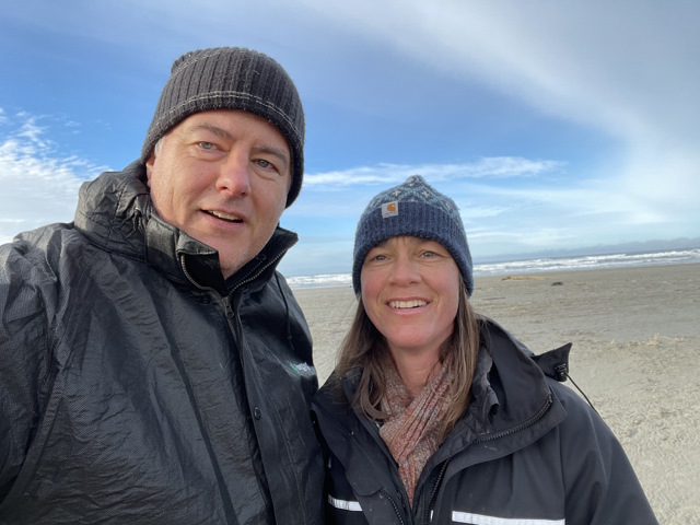 Brett and his wife Molly bundled up in warm clothes at a beach.