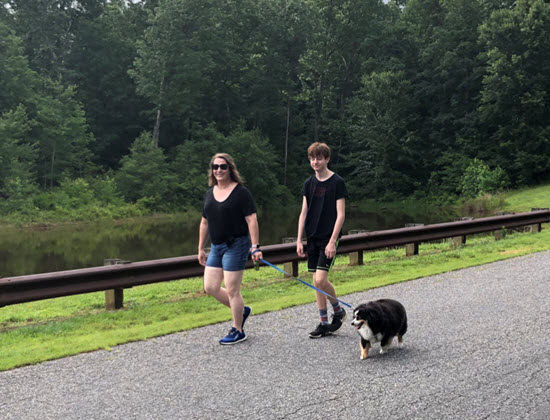 Paula and her son walking their dog in their local neighborhood.