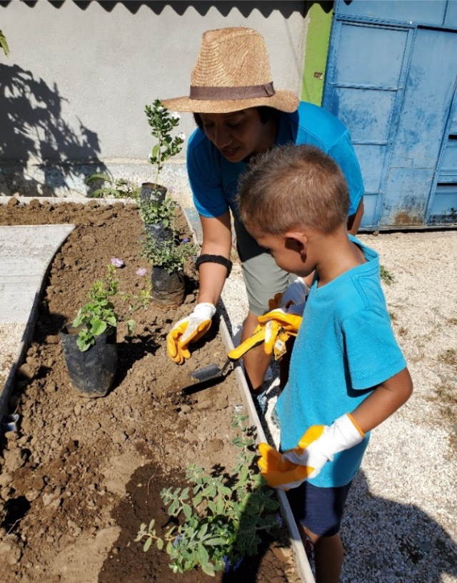 Helping the children plant in their newly built raised garden beds. I taught them the English words for the different parts of the flower.