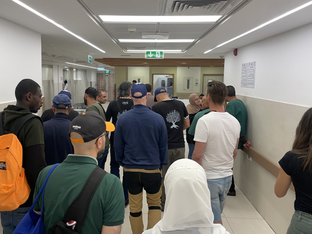 A large group of people in a hospital wing.