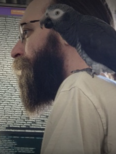 Headshot  of George Huber with a bird on his shoulder.