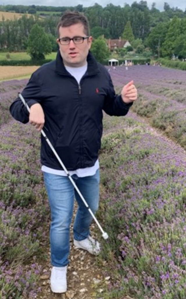 Jack on a walking path surrounded by purple flowers.