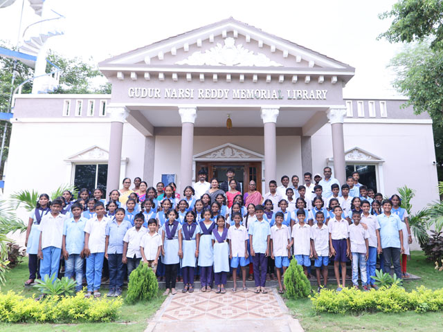 Students and teachers stand outside the new library.