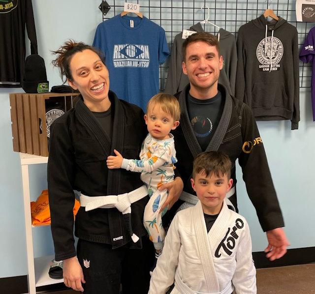 Randy, his wife, and kids wearing martial arts gear. 